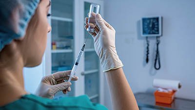 Врач набирает лекарство в шприц